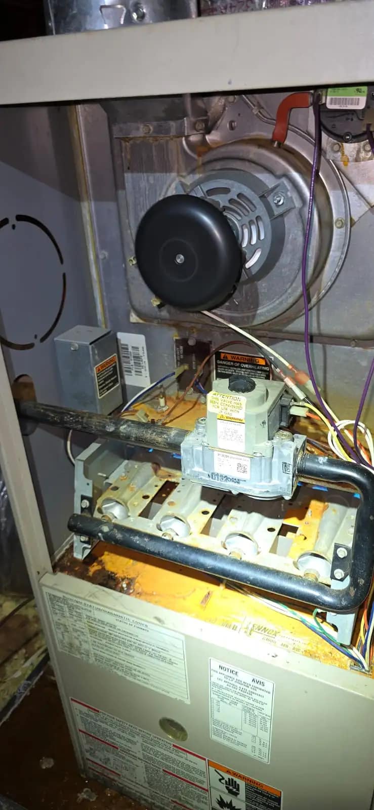 A licensed Texas HVAC technician is inspecting a furnace ignition system in a Tyler attic to troubleshoot why a heater is blowing cold air.